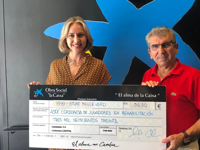 Salvador Secilla, Presidente de Acojer, recibiendo el cheque de Obra Social la Caixa por la directora de la Oficina de la Caixa del Store Boulevard, Carmen Salas.